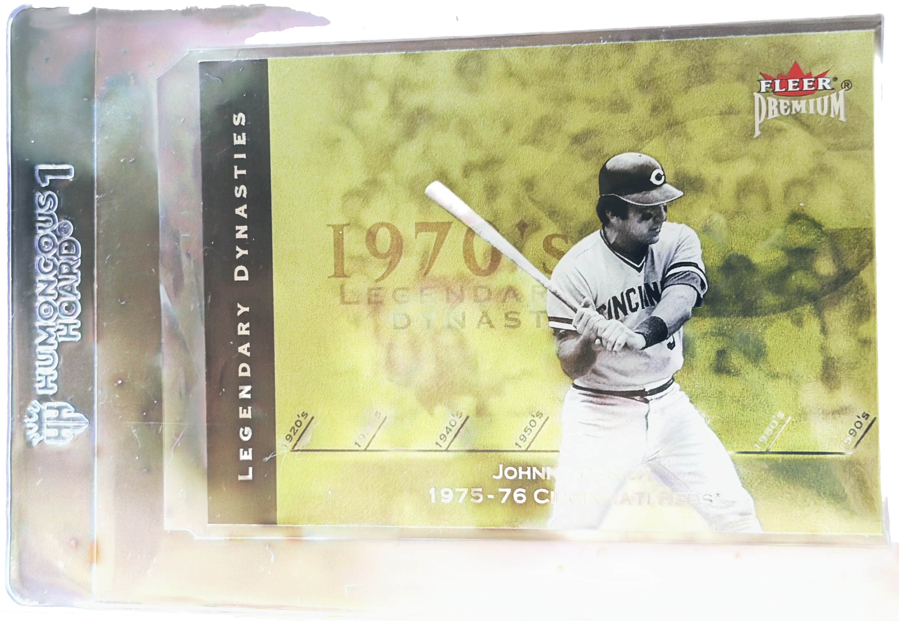 A sports card in a penny sleeve inside a Humongous Hoard semi-rigid holder, shown with a BCW team set bag